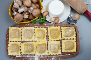 Italian food, fresh home made stuffed pasta ravioli dumplings with ricotta soft cheese and champignons porcini mushrooms, Parma, Emilia Romagna, Italy