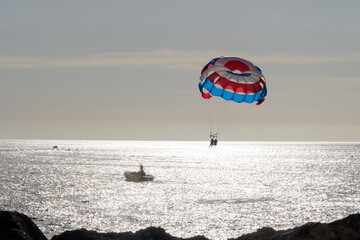 Parasailing or parascending recreational water sport with boat on Tenerife, Costa de Adeje, adventure for tourists
