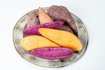 Colorful sweet-tasting tuberous roots vegetables purple and orange organic sweet potatos close up