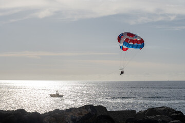 Parasailing or parascending recreational water sport with boat on Tenerife, Costa de Adeje, adventure for tourists