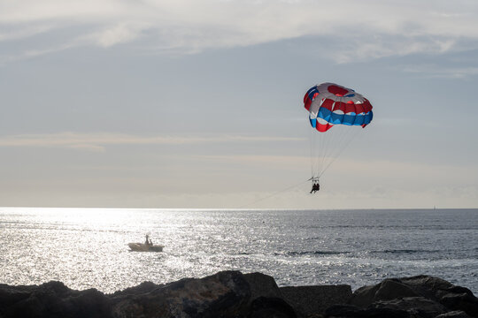 Parasailing or parascending recreational water sport with boat on Tenerife, Costa de Adeje, adventure for tourists