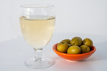 Spanish dry rueda white wine and green olives tapas on white table