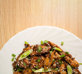 spicy chicken in sweet and sour sauce with onion. teriyaki chicken's with sesame seeds. Chinese cuisine, Thai cuisine. Japanese food, recipe background, food flat lay. Asian food