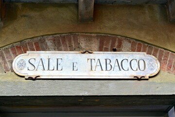 ancient marble sign with the words "salt and tobacco" placed above a shop in the village of Campiglia Marittima in Tuscany, Italy