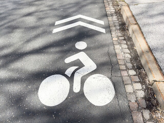 Bicycle lane symbol on asphalt road with directional arrow