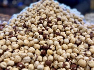 The kernels of peeled hazelnuts on the counter at the market, put up for sale at the supermarket's vegetable stand, showcases organic products, vegetarian food, and healthy food. Close-up