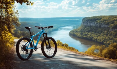 Fototapeta premium Mountain bike parked on scenic overlook with river and lush landscape in background