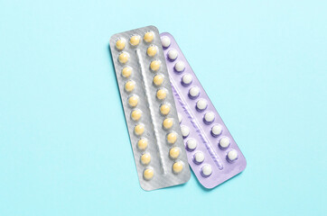 Blisters of contraceptive pills on light blue background, top view