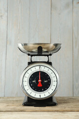 Mechanical kitchen scale with bowl on wooden table