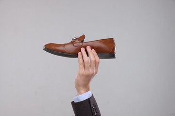 Man with stylish shoe on grey background, closeup