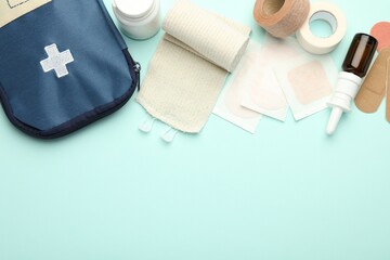 First aid kit. Different medical supplies on light blue background, flat lay. Space for text
