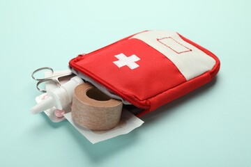 First aid kit. Different medical supplies on light blue background, closeup