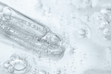 Pipette with cosmetic serum on light background, closeup
