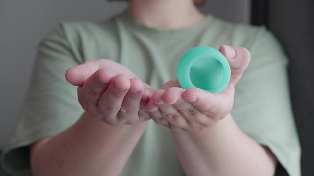 Silicone menstrual cups in woman hand. Woman showing three different alternative ecological feminine hygiene product. menstruation waste-free concept