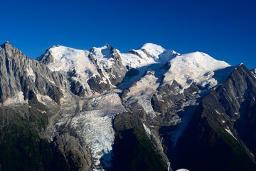 The Mont Blanc massif with the snow-capped Mont Blanc peak, view from the Tour du Mont Blanc path in the western part of the Chamonix valley.