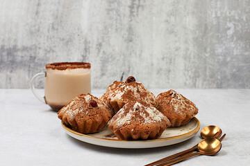 Delicious chocolate muffins with cranberries and milk drink eggnog with cocoa on a gray kitchen table. Advertising card or menu for a cafe, restaurant. Concept of a modern bakery, selective focus.