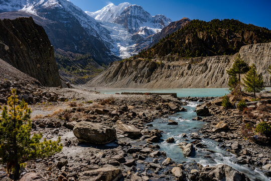 Flowing Mountain Stream Leading to a Turquoise Glacial Lake with Snow-Capped Peaks in Khangsar, Nepal