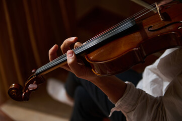 Close-up of a violinist playing a violin with focused skill