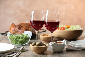 Red wine and delicious dinner served on wooden table