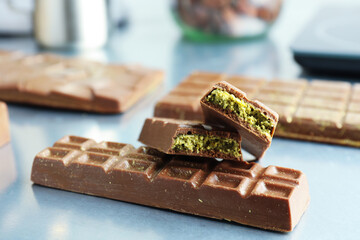Tasty Dubai chocolate with pistachios and knafeh on grey table, closeup