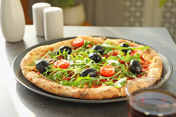 Delicious pizza with olives, cherry tomatoes and arugula on grey table indoors, closeup
