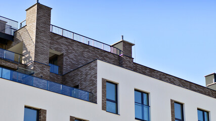 Obraz premium Apartment building with symmetrical modern architecture in the city. Modern apartment building on a sunny day. Facade of a modern apartment building. Bottom view. 