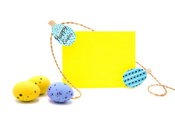Greeting blank card with rope on clothespins with scattered colored eggs isolated on a white background. Copy space. Free space for text. Happy easter! Easter traditional handmade painted eggs.