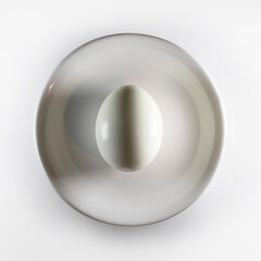 Peeled hard-boiled egg resting on a white plate: minimalist food photography