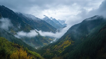 Lush mountains enveloped in clouds with a serene river flowing in the foreground.