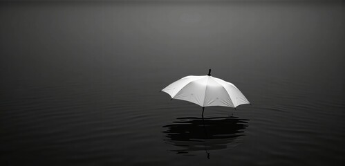 A serene black-and-white image of a white umbrella standing alone in still water, evoking themes of solitude, protection, and tranquility.