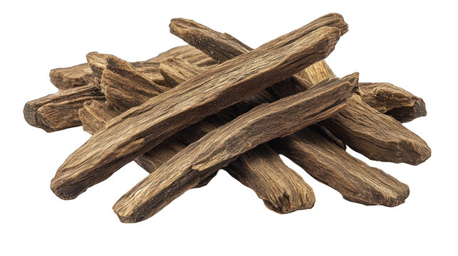 Agarwood logs piled together, showing texture, and detail against dark backdrop