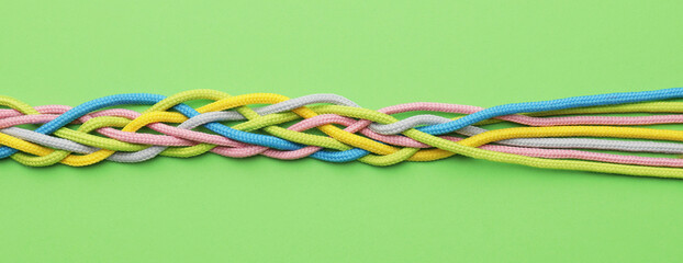 Plaited ropes on color background