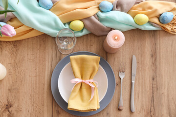 Beautiful Easter table setting with napkins, cutlery and painted eggs