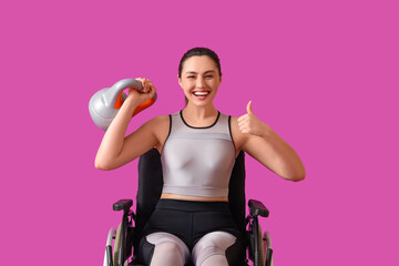 Obraz premium Sporty young woman in wheelchair with kettlebell showing thumb-up on purple background