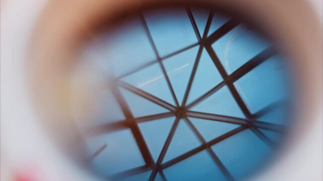 Close up of the reflection of a fence on a cup of tea