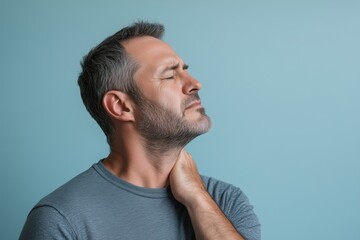 Obraz premium Man suffering from neck pain is touching his sore neck