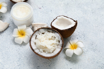 White flowers and jar of natural coconut oil on grunge background, closeup