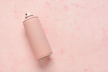 Spray paint can on pink grunge background