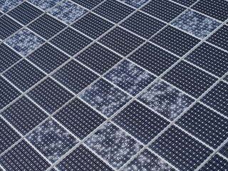 AERIAL: Solar power plant with several broken and cracked panels due to a hailstorm. Damage affects...