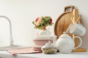 Teapot and dinnerware on counter in kitchen. Closeup