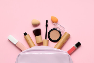 Cosmetic bag with different makeup products on pink background