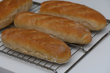 Freshly baked whole grain rolls cooling on a wire rack in a cozy kitchen setting