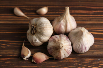 Many fresh garlic and cloves on wooden background