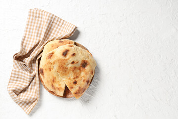 Wooden plate with pieces of tasty lavash on white background