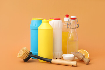 Set of cleaning supplies with baking soda and vinegar on orange background