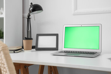 Comfortable workplace with modern laptop in room
