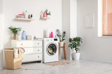 Interior of laundry room with washing machine, commode and basket