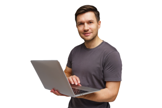 Man smiles while using laptop indoors in casual attire, showcasing technology and connectivity skills