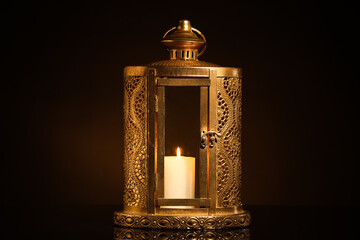 Muslim lantern with burning candle on black background. Ramadan celebration