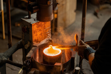 Skilled Artisan Pouring Molten Metal in a Rustic Foundry with Warm Glowing Ambiance